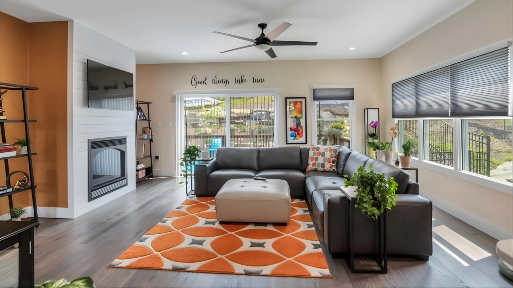 Bright living room with orange decor and a ceiling fan